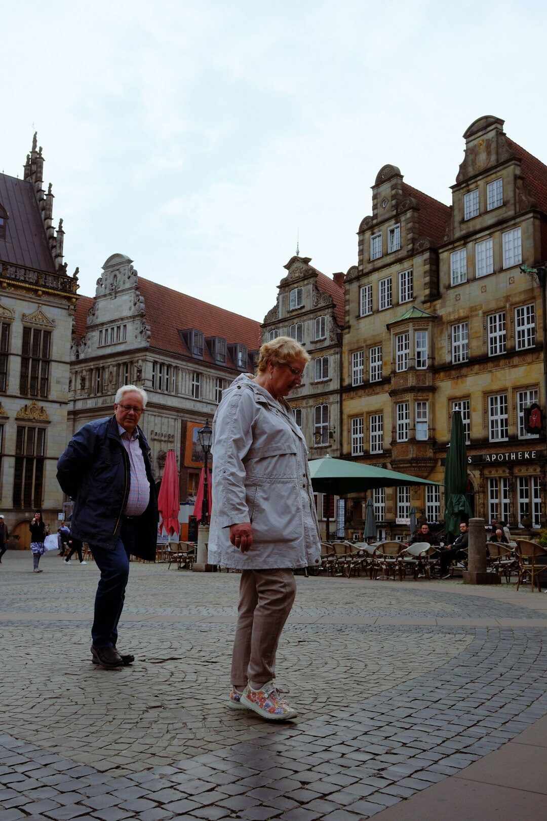 Senior tourists sightseeing in an old European stone town square